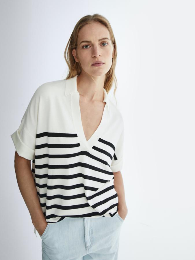 Este polo en color crudo con rayas oscuras es de Massimo Dutti, con escote de pico y cuello de polo que tiene mangas cortas con acabado recogido. Disponible en las tallas S, M y L, tiene un precio de 49,95 euros.