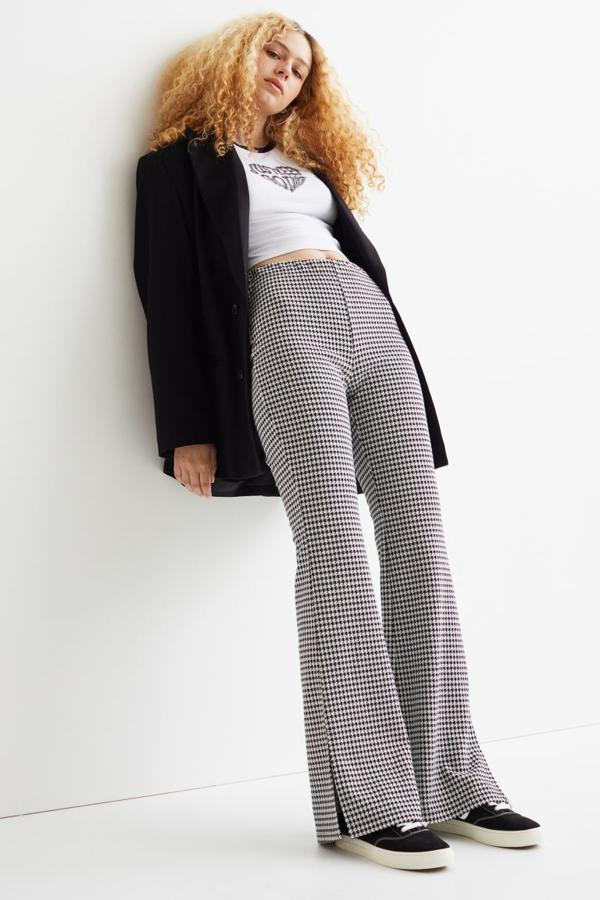Con estampado pata de gallo en su versión más clásica, este pantalón de talle alto con elástico revestido, perneras extralargas y bajo acampanado con abertura es de H&M y podemos comprarlo en su página web por 14,99 euros entre las tallas XS y XL. 