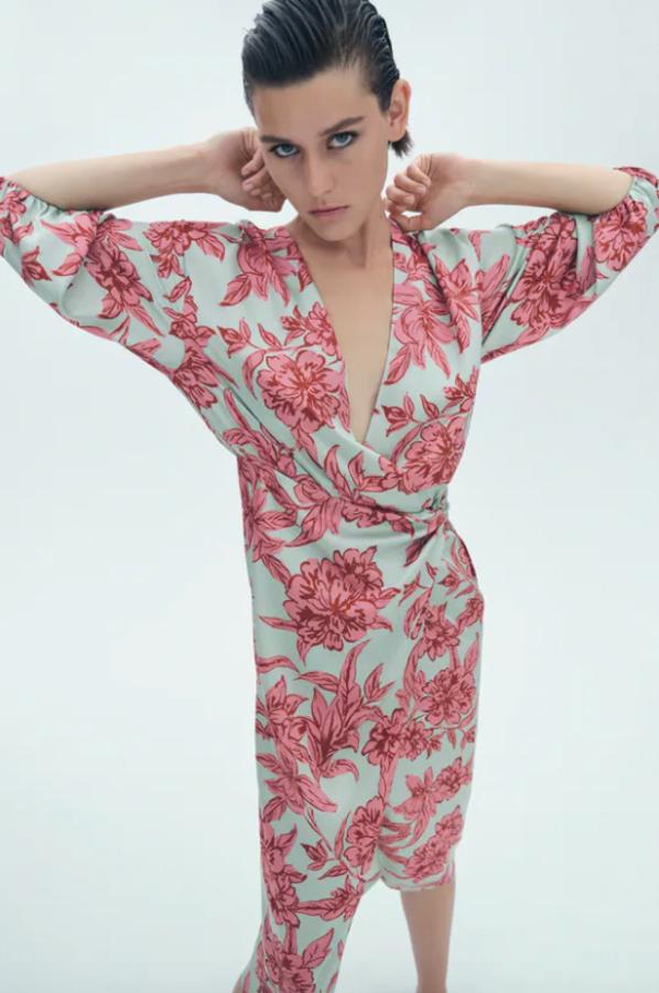 En verde menta con estampado de flores maxi en rosa y rojo, este vestido cruzado de diseño midi tiene escote de pico cruzado, mangas largas acabadas en elástico y detalle de nudo delantero en la cintura con frunces. Con abertura frontal en el bajo, está disponible entre las tallas XS y Xl por 39,95 euros. 