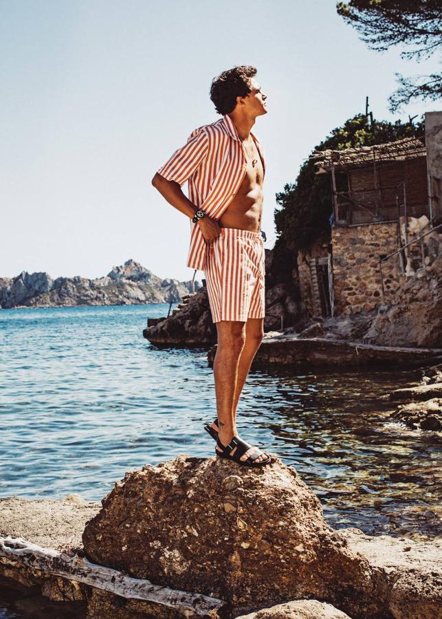 Camisa y bermudas de rayas, de Dockers; sandalias de Hermès y reloj y collar con colgante de oro rosa y cerámica, ambos de Bvlgari.