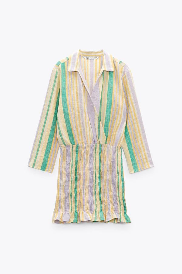 Con estampado de rayas multicolor, este vestido corto de manga larga y escote cruzado cuenta con elástico tipo nido de abeja y bajo acabado en volante. Tiene un precio de 29,95 euros.