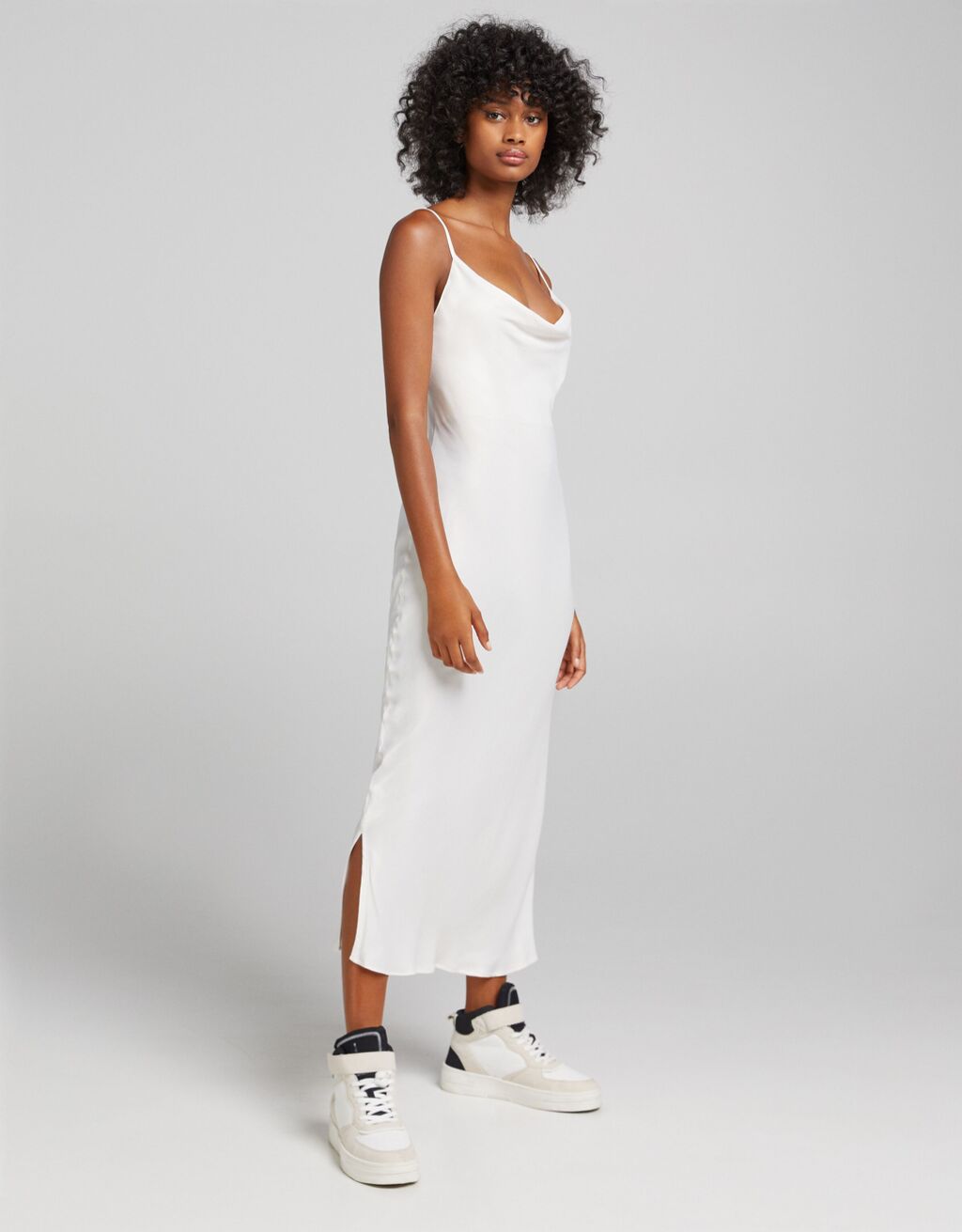 Vestido midi de tirantes finos con efecto satinado y apertura lateral, de Bershka (22,99 €).