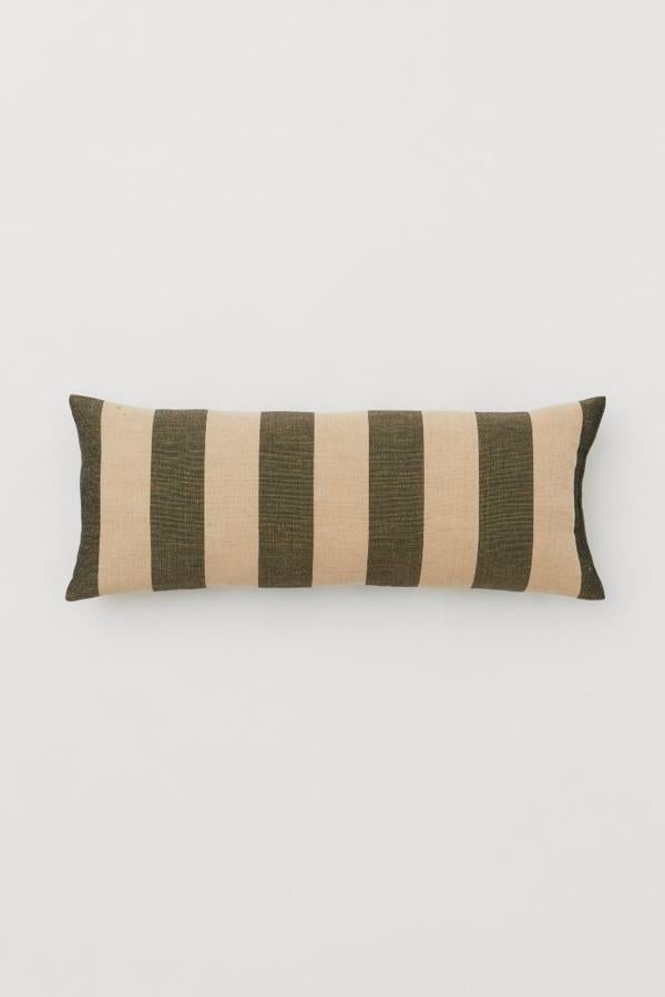 Cojín alargado (30x80 cm) con estampado de rayas de H&M home.Tiene un precio de 29,99 euros.