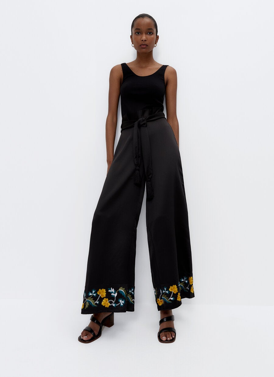 Pantalón ancho de tejido fluido de cintura alta con detalle de lazada y flores bordadas en el bajo, de las rebajas de Uterqüe (39,95 €).