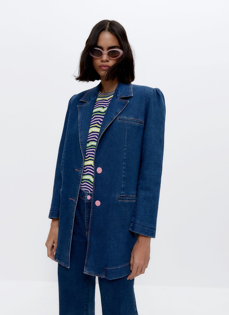 Blazer de corte clásico de tejido vaquero con doble botonadura, hombreras fruncidas y bolsillo laterales, de las rebajas de Uterqüe (59,95 €).