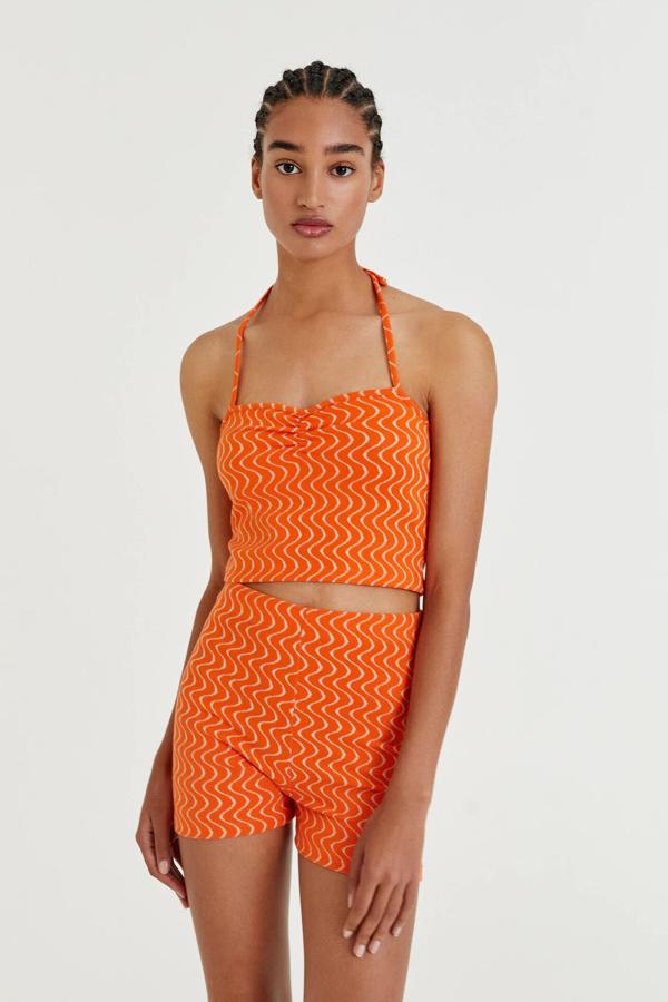 En color naranja con print de ondas, este conjunto está formado por un top (9,99 euros) cropped de tirantes y un short (12,99 euros) a juego.