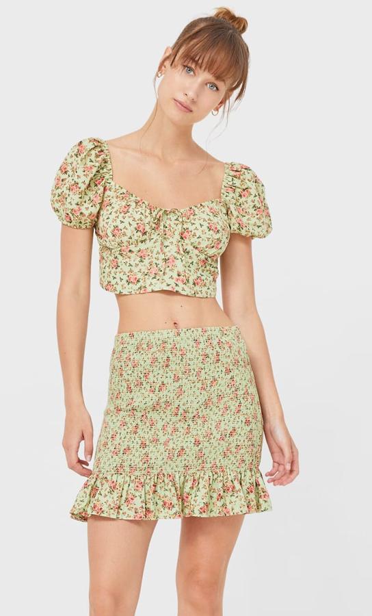 Con estampado de flores y detalle de nido de abeja, esta falda mini de tiro alto y acabado en volantes es de Stradivarius y tiene un precio de 15,99 euros.