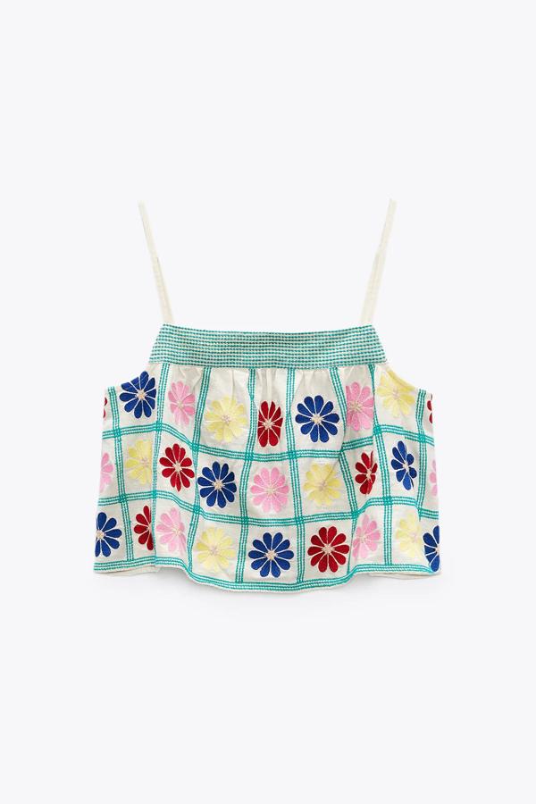 En color crudo y con flores multicolor bordadas, este top corto de tirantes finos y escote recto tiene un precio de 22,95 euros.
