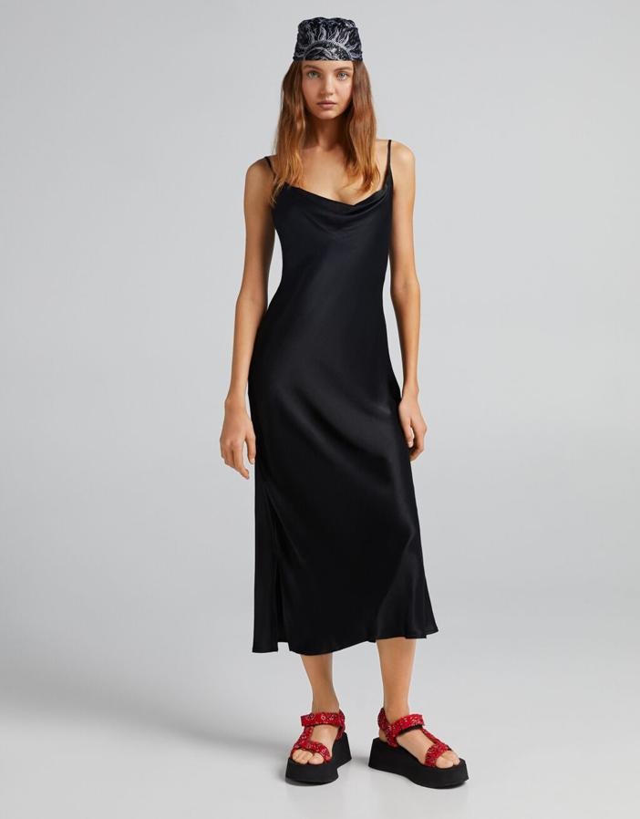 Confeccionado en viscosa sostenible este vestido midi satinado de Bershka de diseño recto, con vuelo y aberturas laterales en el bajo viene con tirantes finos y escote de pico. Disponible entre las tallas XS y L, cuesta 22,99 euros.