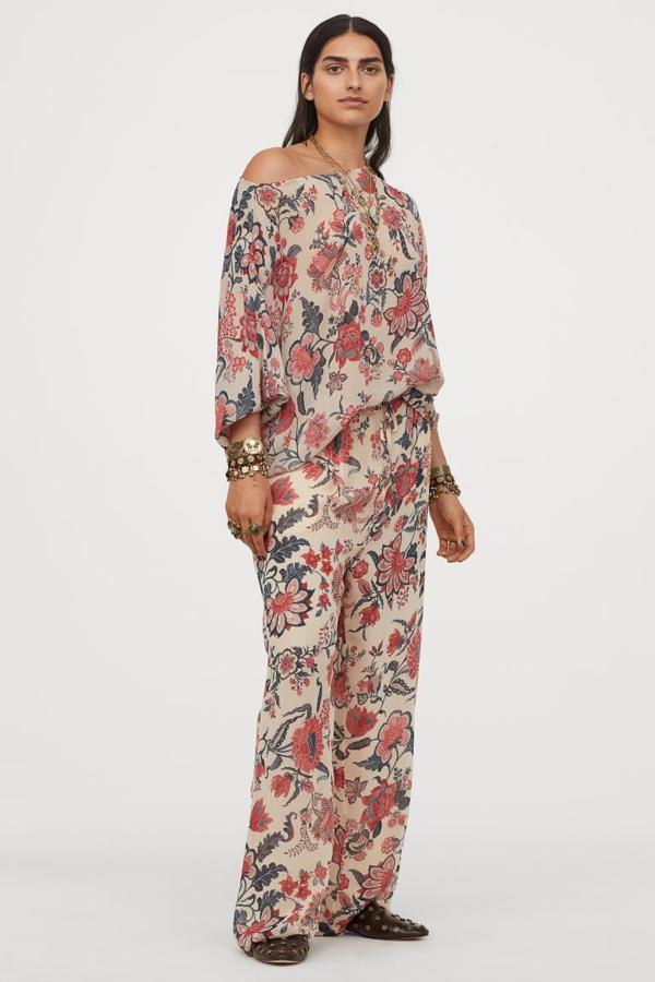 Con estampado de flores en tonos rosas y azules sobre fondo en color crema, este pantalón largo de talle alto con elástico revestido en la cintura, cordón de ajuste delantero y bolsillos al bies cuesta 39,99 euros. La blusa a juego está confeccionada en gasa vaporosa en ligeramente arrugada y es de diseño cuadrado con escote amplio que deja un hombro al descubierto. Cuesta 34,99 euros. 