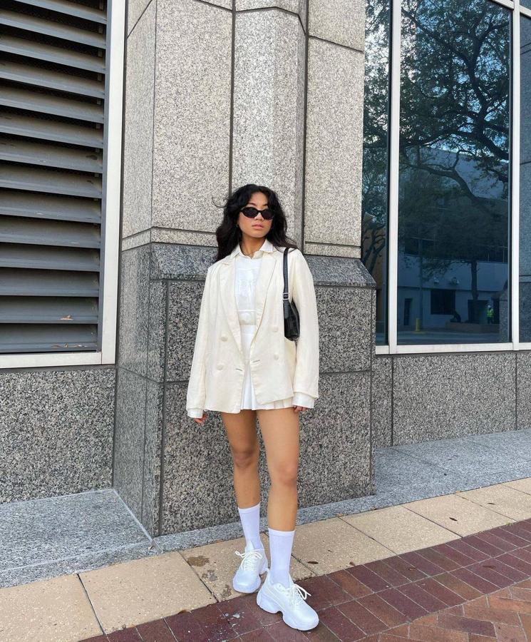 Arreglada pero informal. Una estética de diario perfecta con camisa metida por dentro de la falda de tablas, blazer oversize, bolso baguette y calcetines subidos.