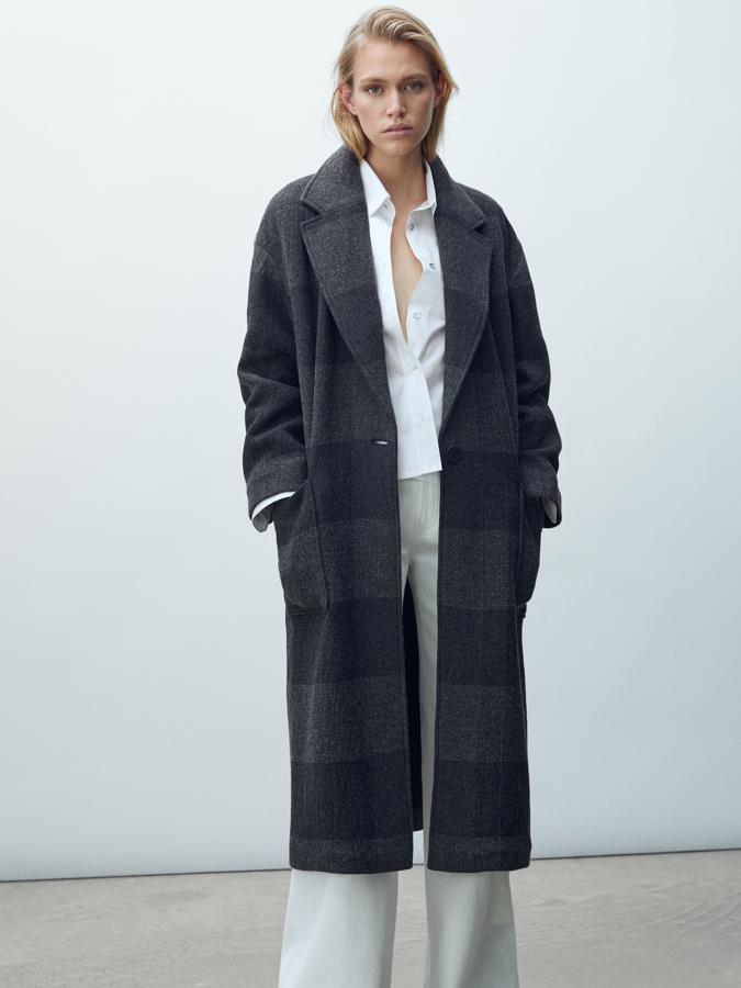 Estampado de cuadros en dos tonos de gris para este abrigo de corte oversize con bolsillos de plastrón en el frontal y cierre mediante un botón. Tiene cuello de solapa con muesca, cuesta 169 euros y está disponible entre las tallas XS y L.