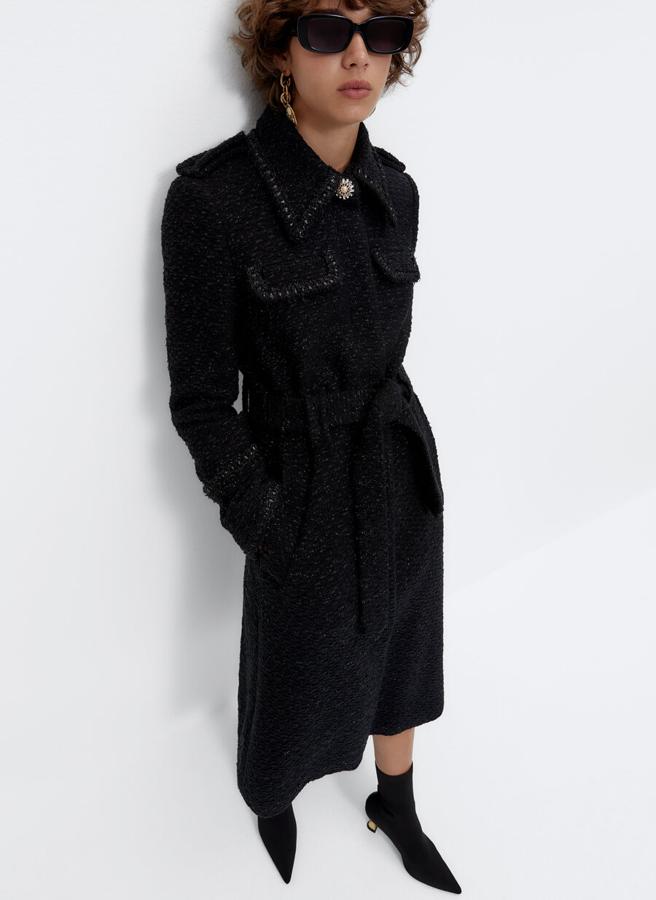 Confeccionado en tejido desflecado, este abrigo negro de Uterqüe con detalle de botón joya en el cuello de solapa viene con bolsillos de plastrón en la pechera, cinturón a tono y charreteras en los hombros. De diseño midi, podemos encontrarlo entre las tallas XS y L por 199 euros.