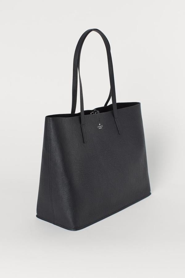 Con exterior en piel sintética grabada e interior en ante sintético, este bolso shopper negro con dos asas de hombro es de H&M y tiene un precio de 19,99 euros. 