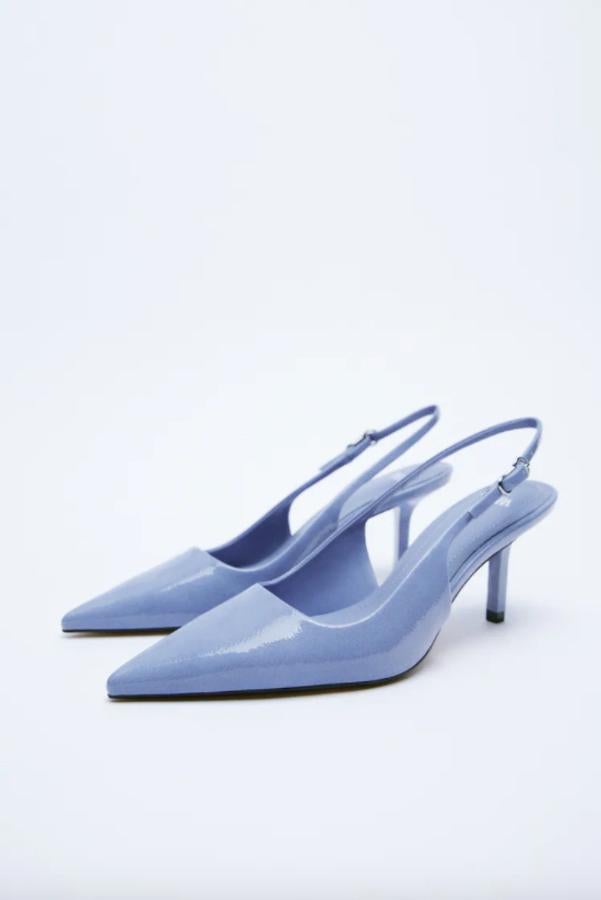 Con efecto acharolado y en color azul, este zapato destalonado con tacón de 7,7 centímetros y acabado en punta es de Zara y viene con cierre de hebilla en el tobillo. Tiene un precio de 35,95 euros.