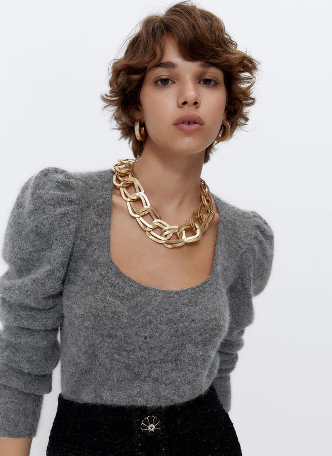 Uno de nuestros favoritos es este precioso jersey confeccionado con alpaca en color gris, que viene con escote cuadrado y mangas largas con hombros abullonados. Con acabados en rib, tiene un precio de 89 euros y está disponible en las tallas S y M.