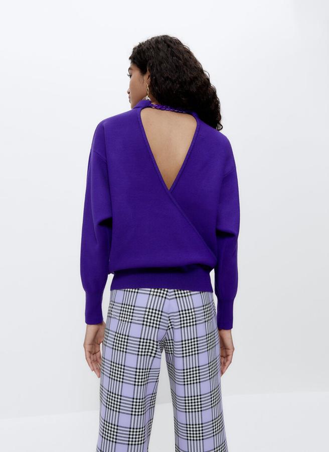 En un intenso color morado, este jersey de punto con cuello redondo con efecto 3D viene con espalda cruzada con detalle de cadena en el escote y acabados en rib. Disponible en las tallas S y M, cuesta 79 euros.