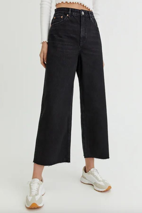Diseño culotte para estos vaqueros negros de Pull&Bear que son de tiro alto y vienen con cinco bolsillos, cintura con trabillas y cierre de botón y cremallera que están confeccionados en algodón. Disponibles entre las tallas 32 y 44, cuestan 19,99 euros. 