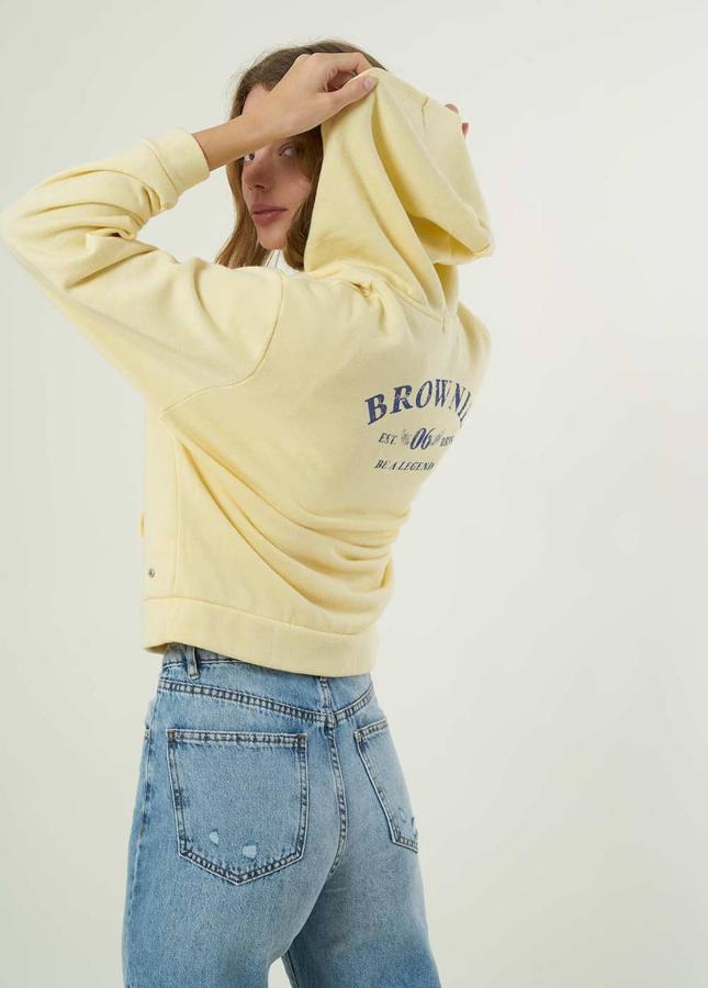 Esta sudadera con cremallera y capucha tiene un bonito color amarillo. Cuenta con un pequeño logo en el frontal y otro de mayor tamaño en la espalda. Cuesta 49,90 €.