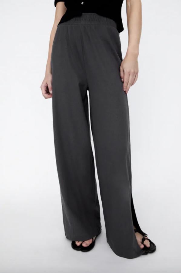 Disponible en marrón topo, en gris antracita o en negro, este pantalón largo de Zara confeccionado al 100% en algodón es de tiro alto, pernera ancha y cintura elástica y cuesta 17,95 euros. Está disponible entre las tallas XS y XL.