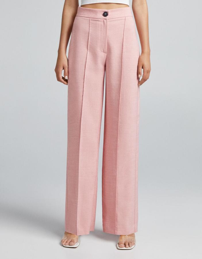 Diseño widde leg para este pantalón de Bershka que ha llegado al catálogo en marrón, rosa, camel y verde agua. Con perneras rectas con raya y bajo por debajo del tobillo, cuesta 19,99 euros y está disponible entre las tallas 32 y 44. 