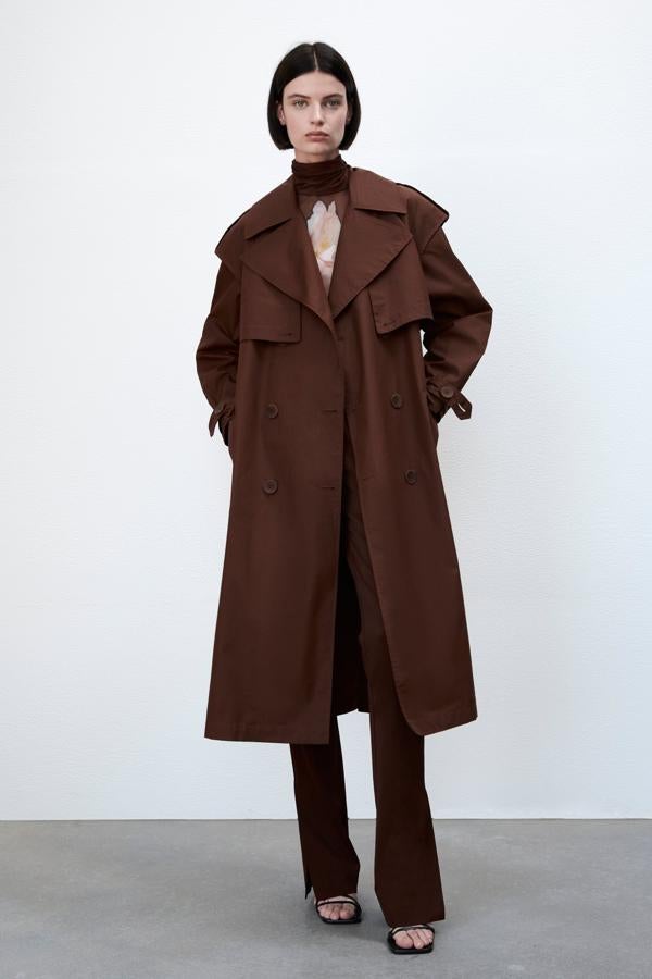 Si hay una prenda que vuelve todos los otoños, esa es el trench. El de color camel es apuesta segura, pero siempre puedes incorporar un color nuevo a tu colección, como el marrón chocolate. Gabardina larga de Zara (79,99 euros)