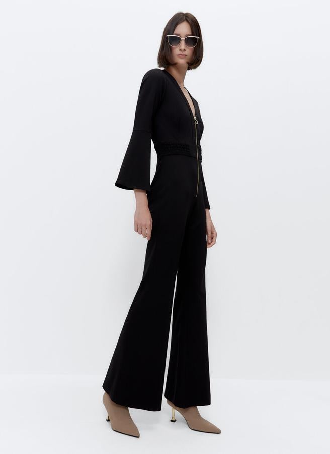 El mono negro es un must en nuestro armario de temporada, y este de Uterqüe confeccionado en tejido de punto, con detalle de cremallera dorada en el cuerpo, es un buen candidato. Tiene las mangas y las perneras acampanadas y la cintura elástica y cuesta 129 euros. Estará disponible entre las tallas XS y L. 