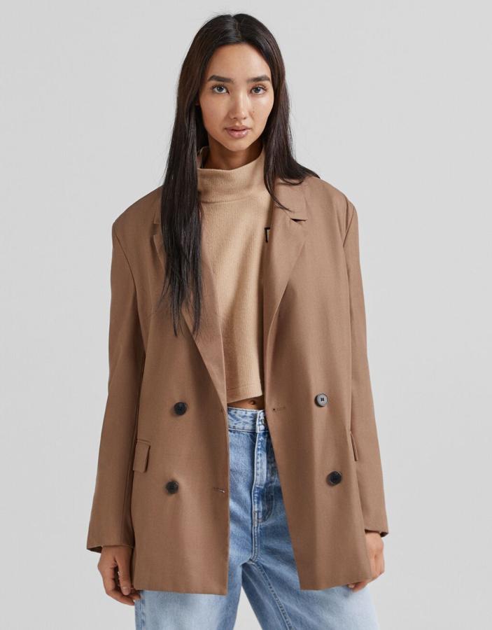 Disponible en color marrón o en beige con estampado de cuadros negros mini, esta blazer de Bershka con doble botonadura frontal a contraste está disponible entre las tallas XS y L por 35,99 euros. 
