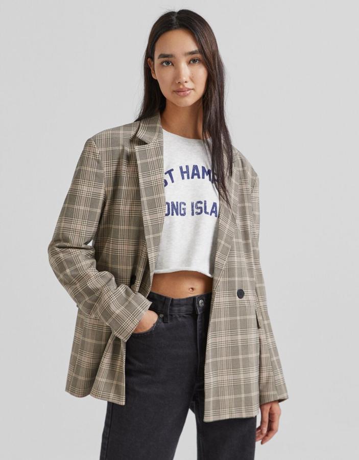 Disponible en color marrón o en beige con estampado de cuadros negros mini, esta blazer de Bershka con doble botonadura frontal a contraste está disponible entre las tallas XS y L por 35,99 euros. 