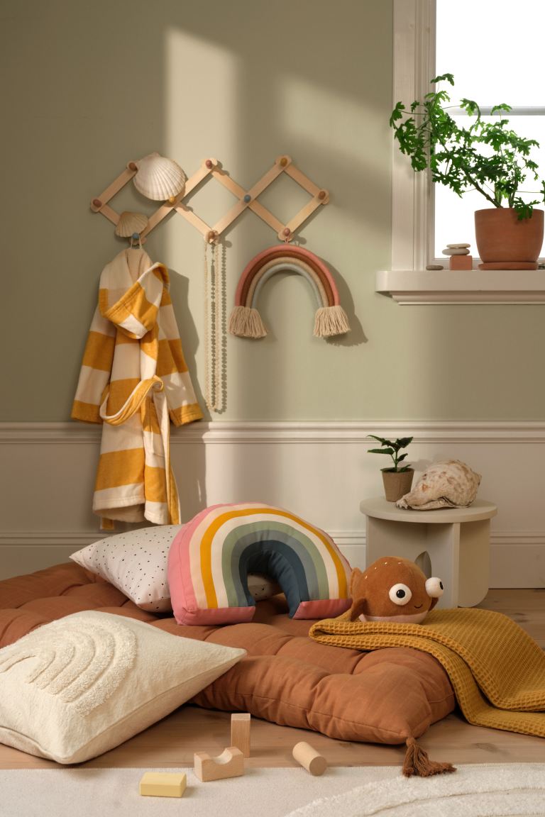 ¿Puede ser más ideal este cojín multicolor en forma de arcoirís para el dormitorio de tus hijos? Cuesta 9.99 euros en H&M Home.