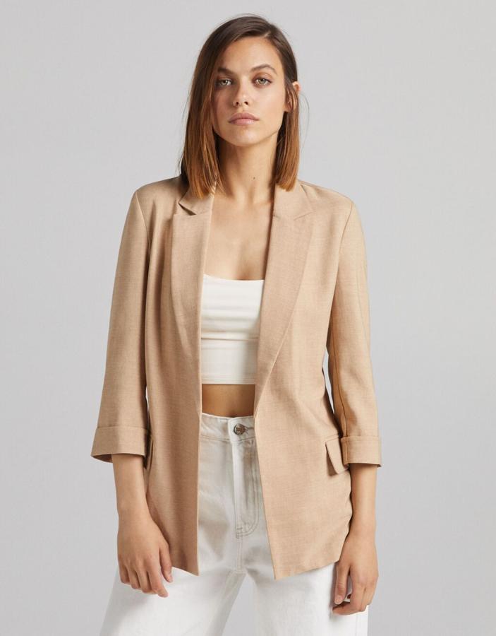 En Bershka se han decantado por el camel y el verde agua para una blazer abierta con bolsillos de solapa y cuello de solapa con muesca. Tiene un precio de 25,99 euros y está disponible entre las tallas XS y XL.