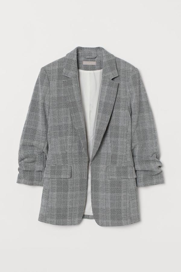 En H&M se han decantado por el diseño entallado para esta blazer que podemos encontrar en beige grisáceo o con estampado Príncipe de Gales en blanco y negro, Con solapas con muesca, manga recogida tres cuartos, bolsillos al bies ribeteados y sin cierre, tienen un precio de 39,99 euros y está disponible entre las tallas 32 y 50. 