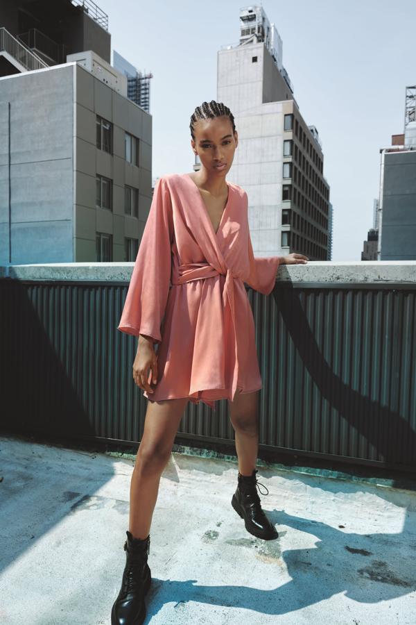 Vestido parece, mono es. Un diseño corto, drapeado en un favorecedor color rosa, que podrás llevar con botines hasta que bajen más las temperaturas. Mono corto de Zara (29,99 euros)