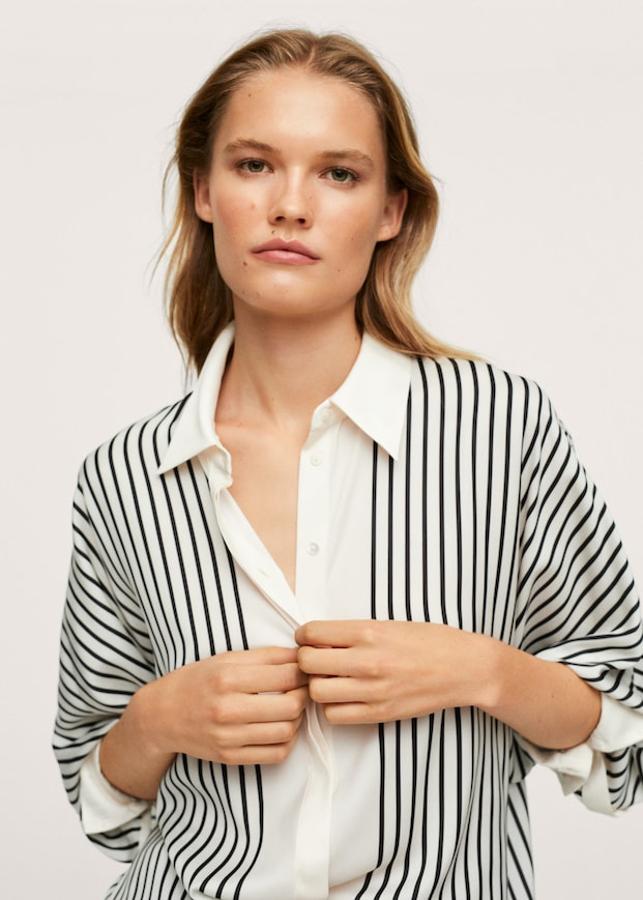 Otra propuesta con rayas verticales de Mango es esta preciosa camisa en tejido satinado fluido y diseño oversize en blanco roto con estampado en negro. Con cuello clásico y mangas largas con puños abotonados, tiene la costura del hombro caída y cierre de botones frontal oculto por tapeta. Podemos encontrarla por entre las tallas XXS y 4XL por 29,99 euros. 