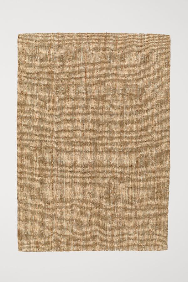 Esta alfombra beige jaspeada en tejido grueso de yute mide 170x240 centímetros y tiene un precio de 149 euros.