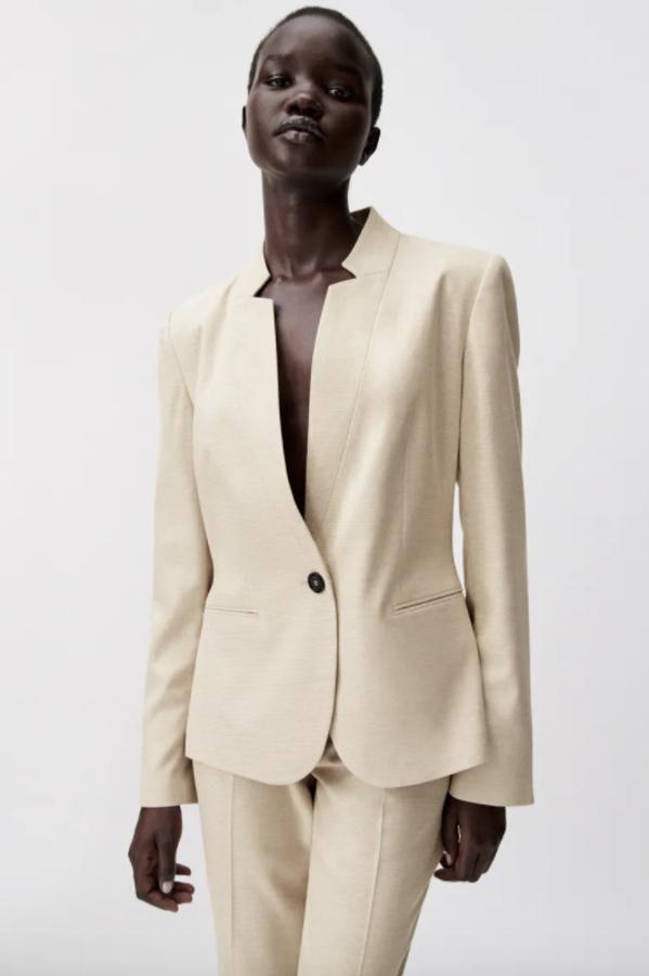 En color beige y de diseño entallado, esta blazer de Zara con solapas invertidas con muesca y mangas largas con hombros marcados viene con bolsillos delanteros de doble vivo y bajo con abertura en la espalda. Con cierre frontal de un botón a contraste, está disponible entre las tallas 34 y 44 por 29,95 euros.