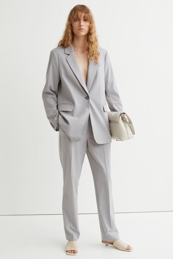 En gris claro y botonadura frontal sencilla, esta americana con solapas de muesca y bolsillos insertados con solapa viene con botones decorativos a tono en los puños y abertura en el bajo en la espalda. Con forro de satén en poliéster reciclado, es de H&M, cuesta 29,99 euros y podemos encontrarla entre las tallas XS y XXL. 