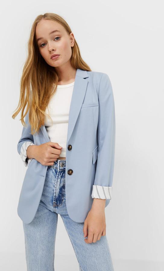 Esta americana de punto que podemos encontrar en Stradivarius en gris mezcla, azul celeste y negro viene con cuello de solapa con muesca, bolsillos laterales con solapa, hombreras y mangas con vuelta con forro estampado. Están disponibles entre las tallas XS y XL por 29,99 euros. 