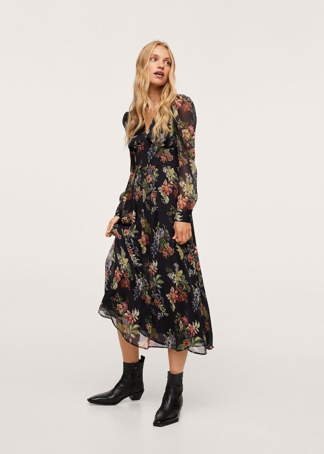En tejido fluido semitransparente y diseño acampanado, este vestido de Mango de fondo negro con estampado de flores verdes, azules rosas viene con escote de pico, mangas largas con puños abotonados y cierre de cremallera y botones. Con panel elástico en la espalda, tiene un precio de 49,99 euros y está disponible entre las tallas XXS y 4XL, menos en la S. 