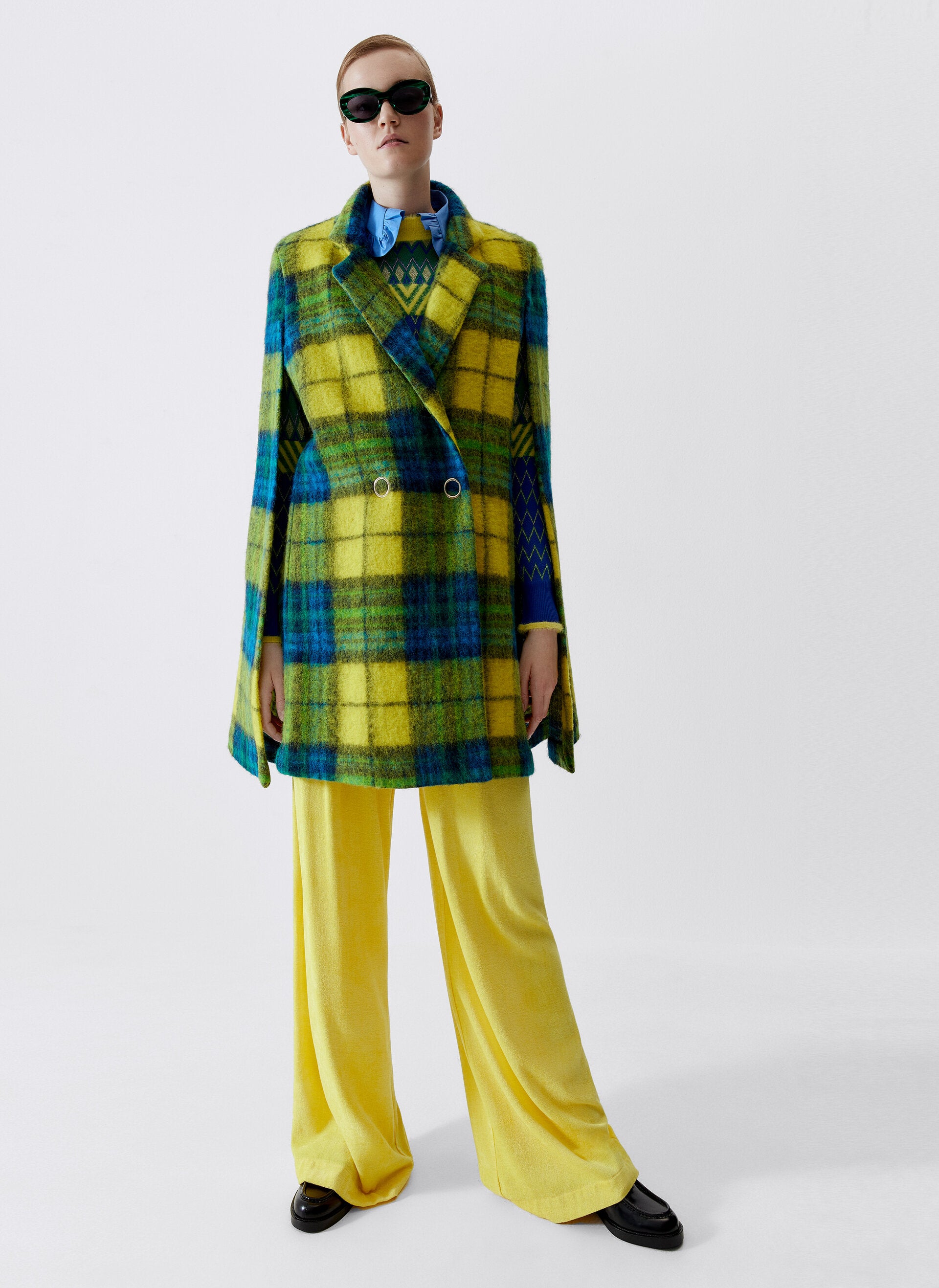 Este abrigo capa con estampado de cuadros en amarillo, azul y verde (99 euros).