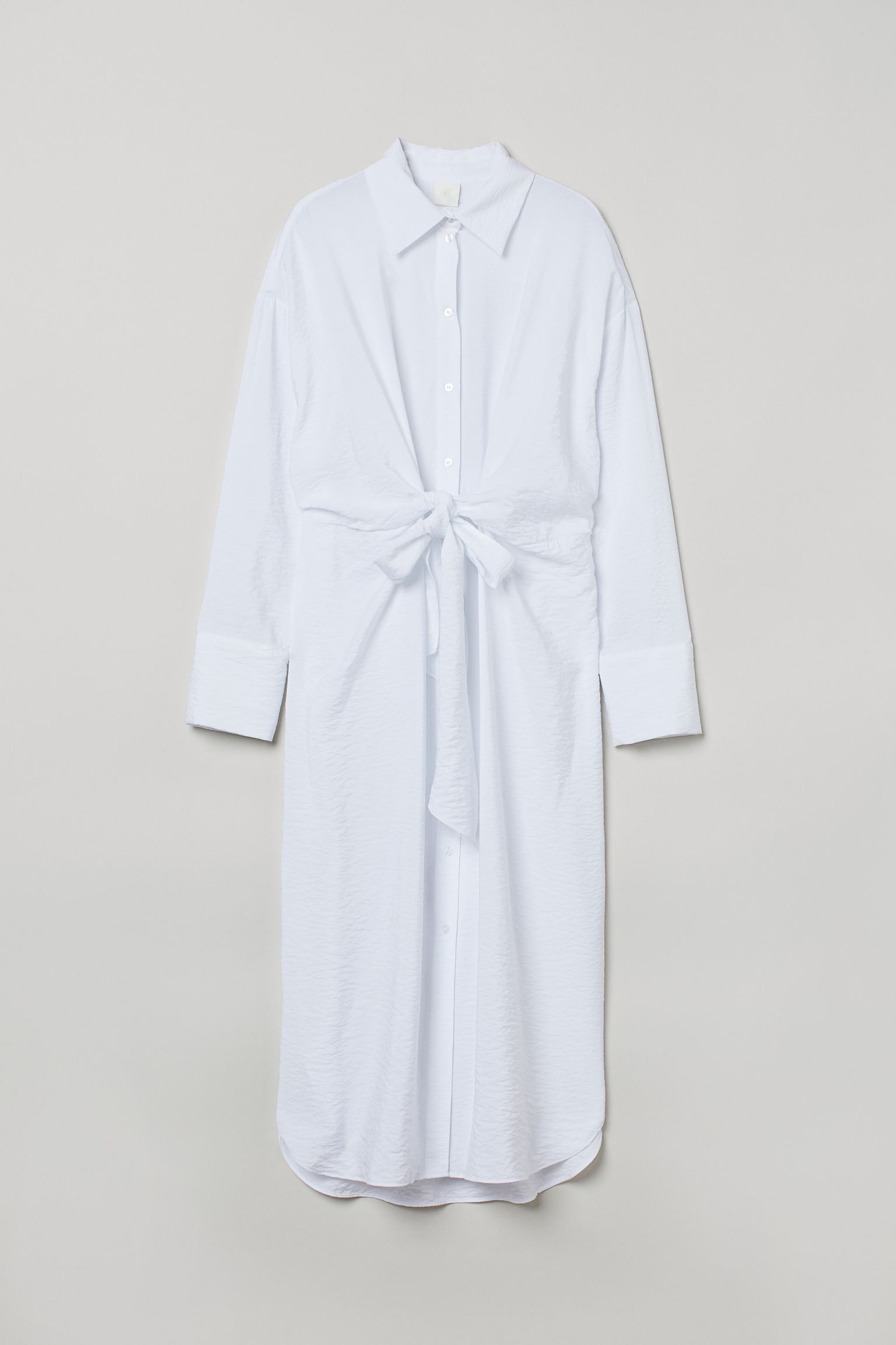 Versátil y muy ponible, este vestido camisero blanco con lazo de H&M cuesta 24.95 euros.