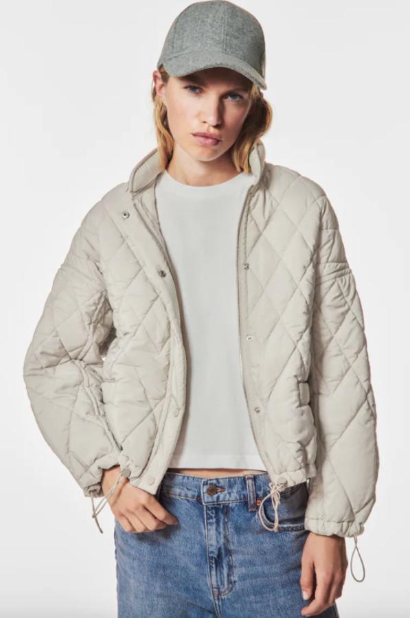 Disponible en beige y en negro, esta chaqueta acolchada de cuello subido con capucha plegable y mangas ajustables con elástico y stopper es de Zara y viene con bolsillos de vivo con botón a presión en delantero y bajo asimétrico acabado en elástico y stopper. Cuesta 39,95 euros y está disponible entre las tallas XS y L. 