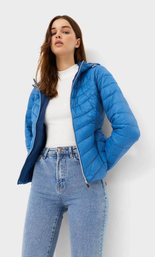 Disponible en cuatro tonos, verde, azul, negro y blanco, esta cazadora acolchada con capucha y mangas largas de Stradivarius con bolsillos invisibles y ajuste de cordón en el bajo tiene un precio de 22,99 euros y está disponible entre las tallas XS y XL. 