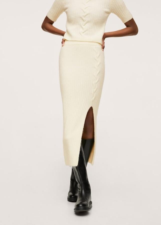 A juego con el jersey, esta falda de punto de Mango en color crudo en diseño de canalé recto y midi viene con cintura elástica y abertura lateral. Disponible entre las tallas XS y XL, cuesta 39,99 euros.