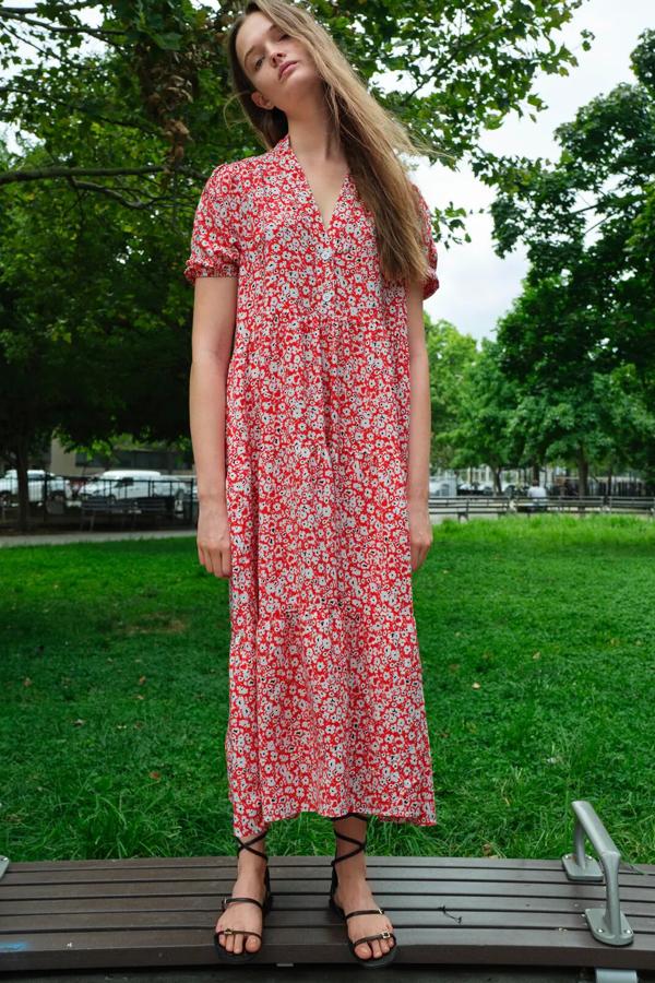 De corte midi y escote de pico, este vestido con estampado floral en blanco y rojo cuenta con manga corta abullonada y bajo acabado en paneles. Es de Zara y tiene un precio de 29,95 euros.