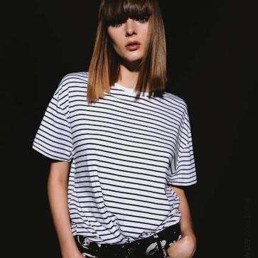 Imagen secundaria 1 - El trench cuesta 19.99 euros en Lefties, la camiseta de rayas, 9.95 euros en Zara, y los mom jeans etsán rebajados a 10.99 euros en H&M.