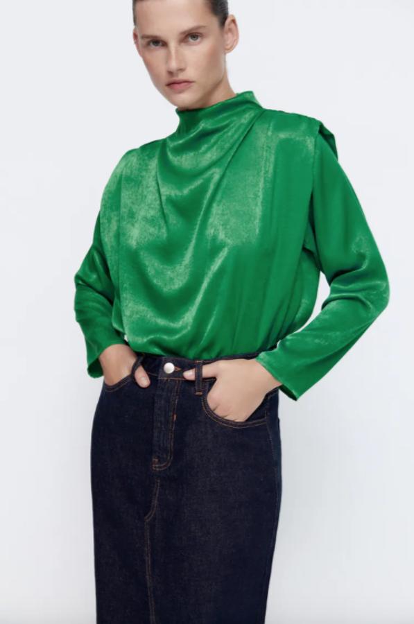 En color verde y con cuello subido, esta blusa de hombros marcados y drapeados es de Zara y tiene cierre en espalda con abertura y botones. Cuesta 25,95 euros y está disponible entre las tallas XS y XL. 