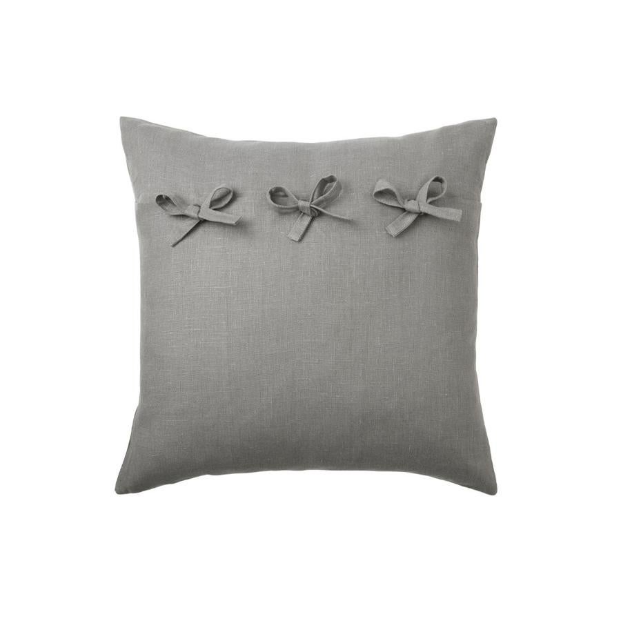Funda de cojín (7 euros) en gris con lazos y dimensiones de 50x50 cm.