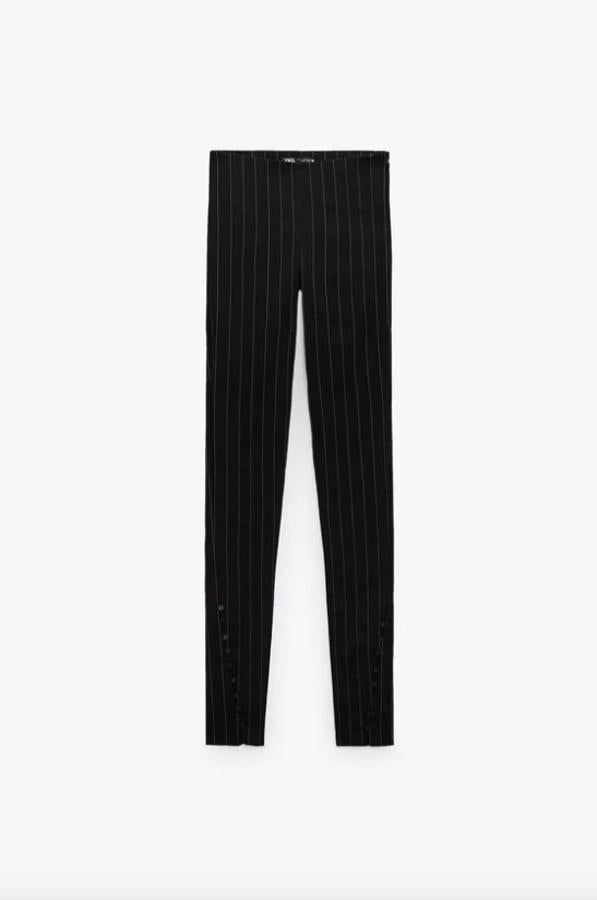 Con estampado de raya diplomática gris sobre fondo negro, estos leggings de tiro alto de Zara con bajo con abertura y botones cuestan 25,95 euros y están disponibles entre las tallas XS y XL. 