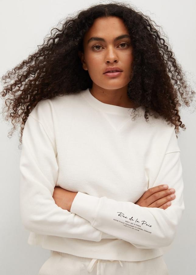 Confeccionada en tejido combinado en color blanco, con mensaje estampado en un lateral de la manga, esta sudadera recta de cuello redondo y terminaciones de canalé cuesta 19,99 euros y está disponible entre las tallas XS y XL.